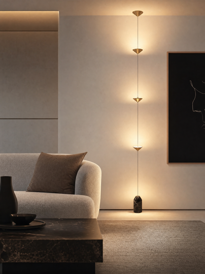 Hora copper floor lamp glowing beside a sofa in a living room